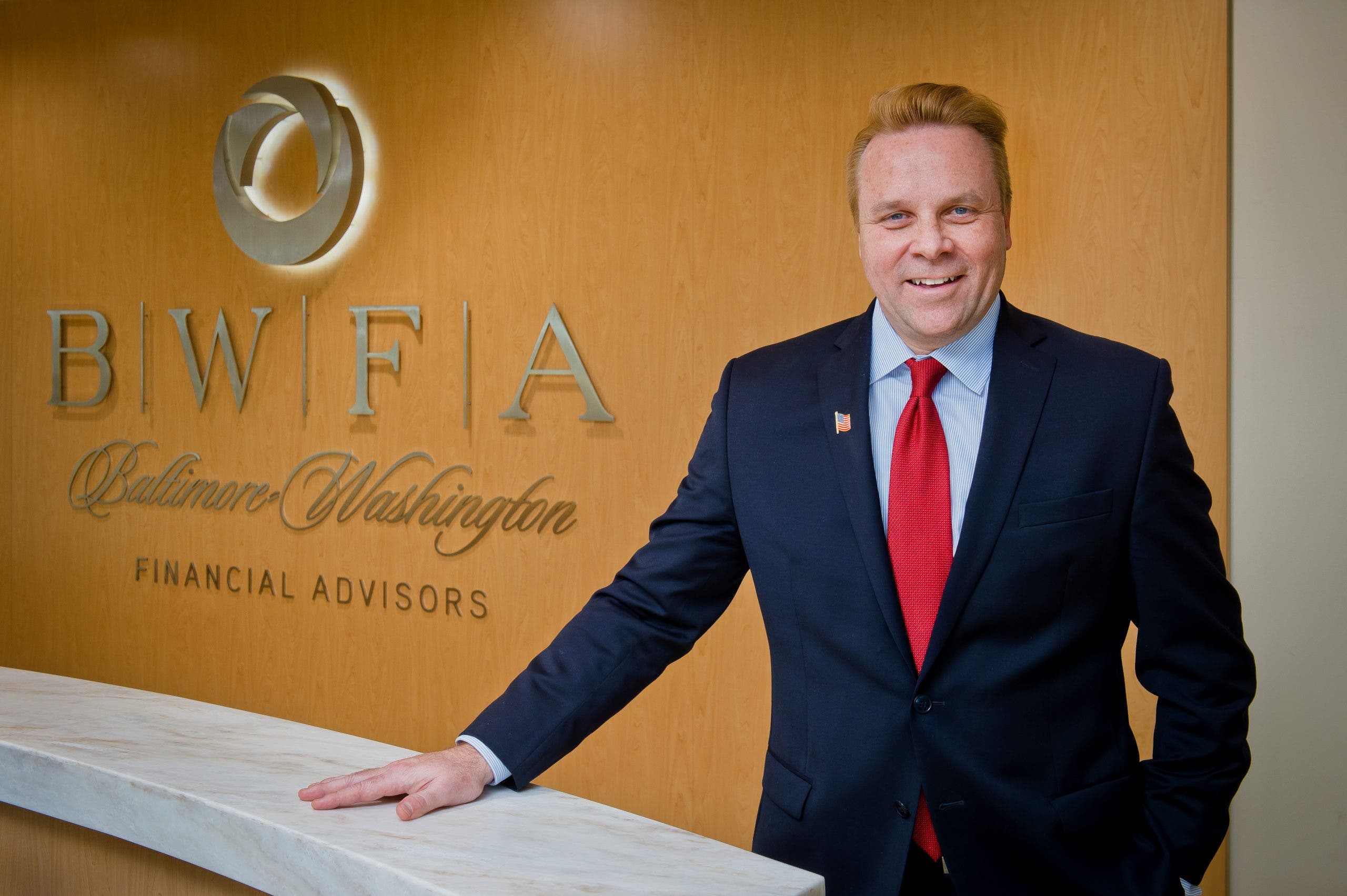 Rob Carpenter stands in front of Baltimore Washington Financial Advisors sign